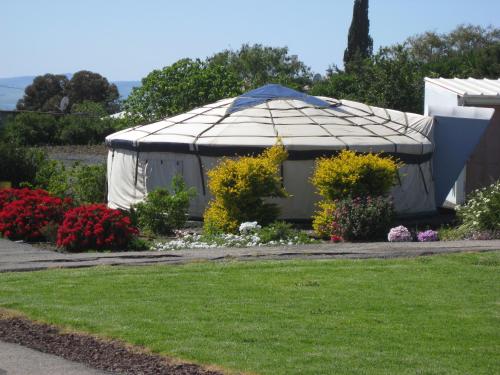 a large white gazebo in a garden with flowers at Sea of Galilee - Genghis Khan in The Golan in Giv'at Yo'av