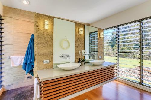 two sinks on a counter in a bathroom with windows at Calanthe Acreage - Doonan in Doonan