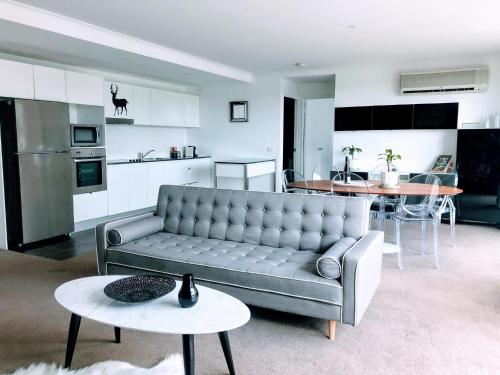 a living room with a couch and a table at Staying Places - The Avenue in Canberra