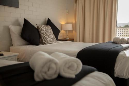 a hotel room with two beds with towels at Herston Place Motel in Brisbane