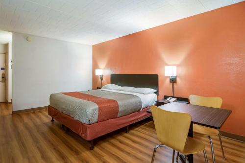 a bedroom with a bed and a table and chairs at Motel 6-New Stanton, PA in New Stanton