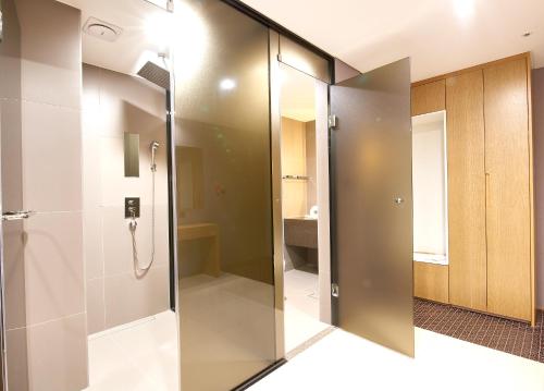 a glass shower door in a bathroom with a toilet at Hotel tt Seomyeon in Busan