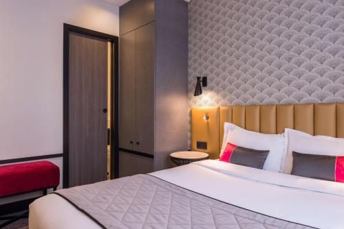 a hotel room with a large bed and a red chair at Best Western Select Hotel in Boulogne-Billancourt