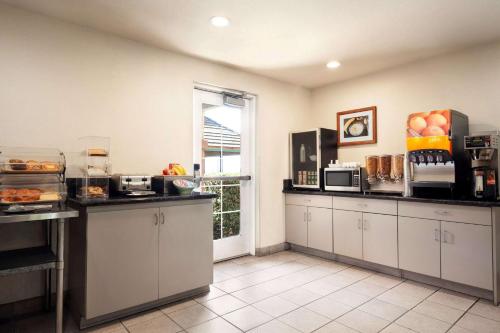 a large kitchen with white cabinets and a window at Microtel Inn & Suites Lodi in Lodi
