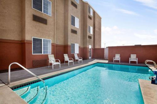 a swimming pool with chairs and a building at Microtel Inn & Suites Lodi in Lodi