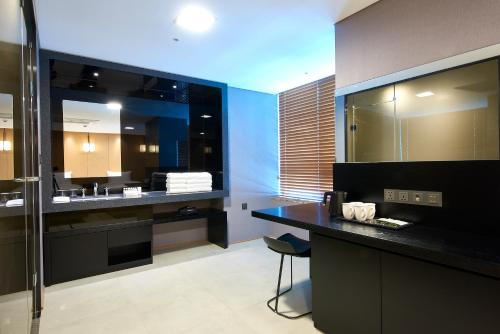 a bathroom with a sink and a vanity with a mirror at Hotel tt Seomyeon in Busan