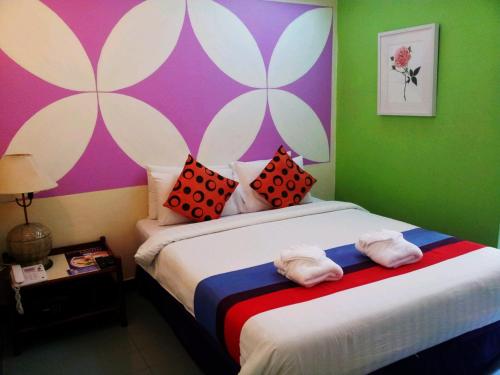 una camera da letto con un grande letto con una parete colorata di Sawasdee Sukhumvit Inn a Bangkok
