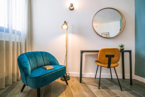 a room with a blue chair and a mirror at Roxon Sea Sand Bat Yam in Bat Yam