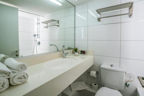 a white bathroom with a sink and a toilet at Roxon Sea Sand Bat Yam in Bat Yam