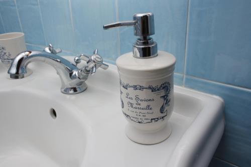 a white soap dispenser sitting on a bathroom sink at Borgo Tepolini Country House in Castel del Piano