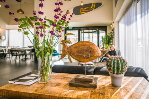 a table with a vase of flowers and a cactus at Roxon Sea Sand Bat Yam in Bat Yam