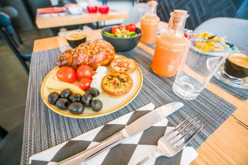 a table topped with a plate of doughnuts and fruit at Roxon Sea Sand Bat Yam in Bat Yam