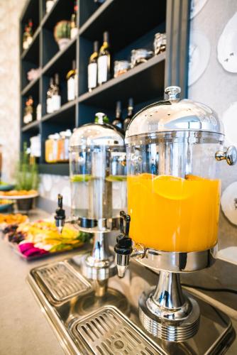 a blender filled with orange juice sitting on a kitchen counter at Roxon Sea Sand Bat Yam in Bat Yam