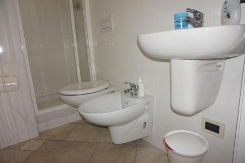 a white bathroom with a sink and a toilet at Bergamum F.L. in Bergamo