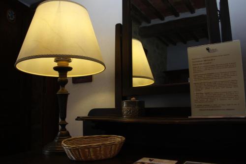 a lamp sitting on a table next to a mirror at Borgo Tepolini Country House in Castel del Piano