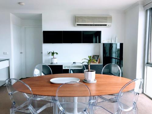 a dining room with a wooden table and chairs at Staying Places - The Avenue in Canberra