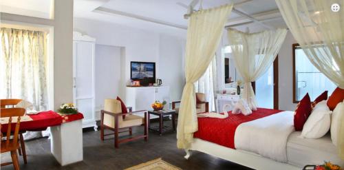 a bedroom with a red and white bed and a desk at Red sparrow in Munnar