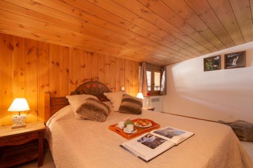 a bedroom with a bed with a tray of food on it at Résidence Le Cristal - Lognan 7 - Happy Rentals in Chamonix