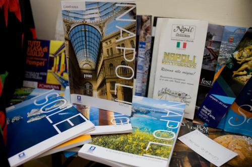 a table topped with books and pamphlets on a table at Hotel Cineholiday in Naples