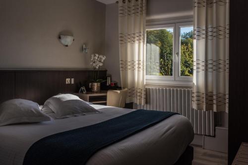 a bedroom with a large bed and a window at Le Rhien Hôtel-Restaurant in Ronchamp