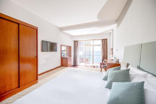 a bedroom with a large bed and a large window at Novotel Nha Trang in Nha Trang