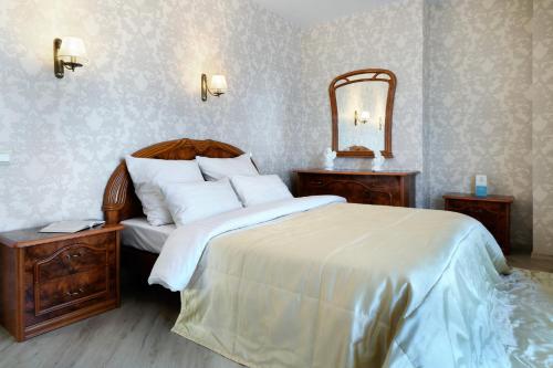 1 dormitorio con 1 cama grande y espejo en PaulMarie Apartments on Yakubovskogo, en Mogilev