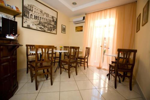 a dining room with a table and chairs and a window at Hotel Cineholiday in Naples