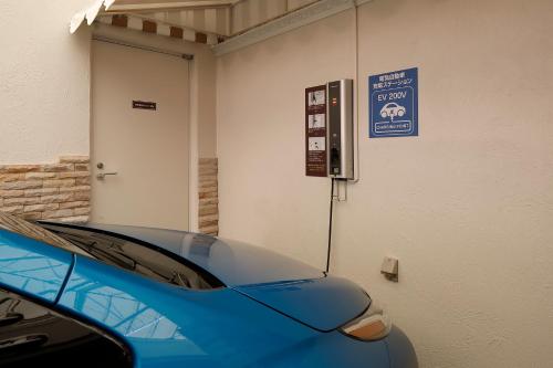a blue car parked in a garage next to a door at Hotel ValentineTogo (Adult Only) in Togo