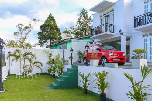 a red car parked in the courtyard of a house at Hotel Mount Castle in Hatton