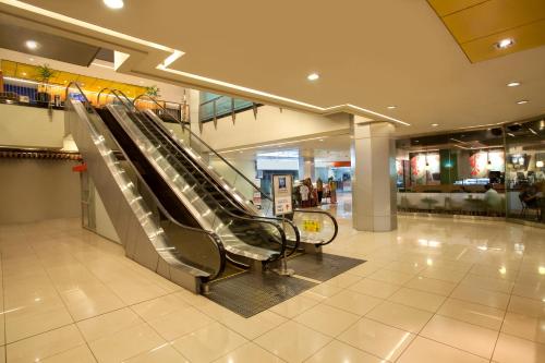 an escalator in a shopping mall with escalators at Ibis Budget Jakarta Menteng in Jakarta