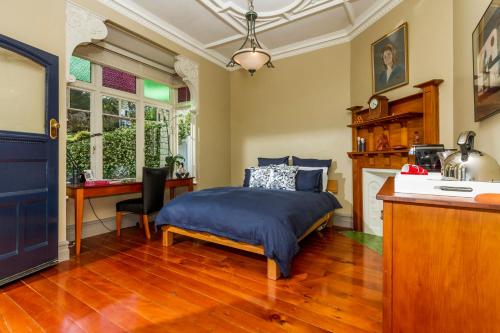 sypialnia z łóżkiem i biurkiem w obiekcie Devonport Harbour View w Auckland
