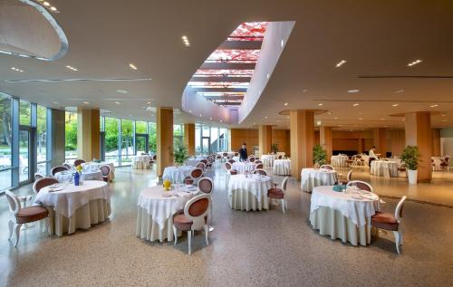 a banquet hall with white tables and chairs at Ethra Reserve Kalidria in Castellaneta Marina