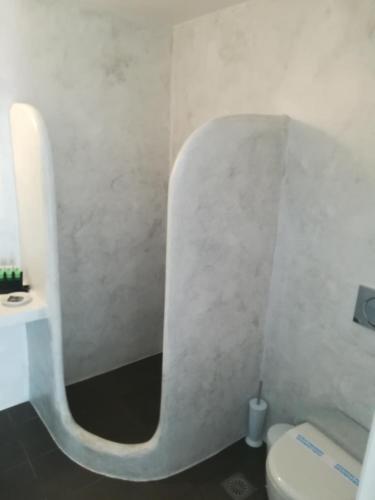 a white bathroom with a toilet and a sink at Villa Irini in Naousa