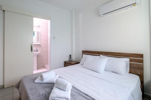 拉納卡的住宿－The Coral Penthouse，卧室配有带毛巾的大型白色床