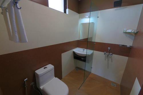 a bathroom with a toilet and a glass shower at Tea Castle Munnar in Munnar