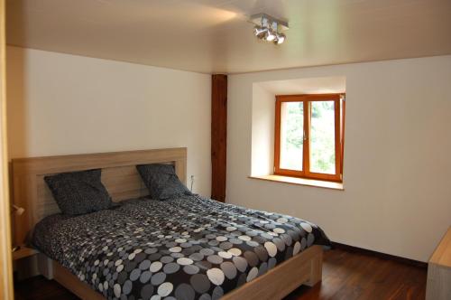 1 dormitorio con cama y ventana en gite Blanche Graine, en Lapoutroie