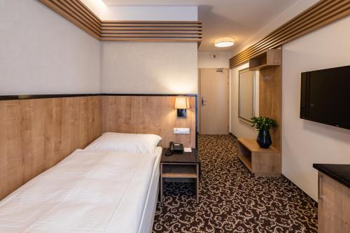 a hotel room with a bed and a flat screen tv at Urpí­n City Residence in Banská Bystrica