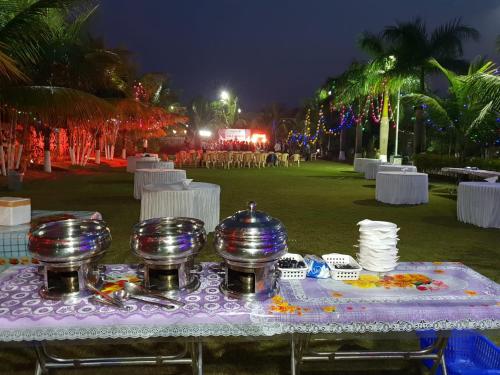 a table with plates and bowls on top of it at Anand Agro Tourism Kashid in Alibaug