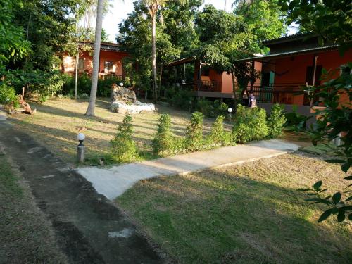 a garden with a path leading to a house at Pim Bungalow in Mae Haad