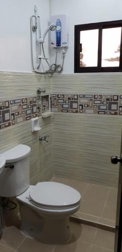 łazienka z toaletą i oknem w obiekcie KDC Homes (Gold) w mieście Puerto Princesa