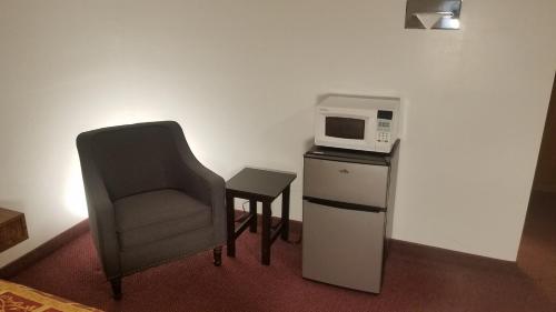 a room with a chair and a microwave at Amber Inn Motel in Bliss