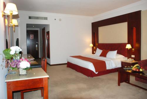 a hotel room with a large bed and a desk at Safir Hotel Cairo in Cairo