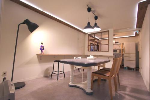 a dining room with a table and a lamp at I Osaka Traditional in Osaka