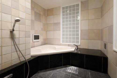 La salle de bains est pourvue d'une baignoire et d'une fenêtre. dans l'établissement Hotel ValentineTogo (Adult Only), à Togo