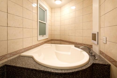 a bathroom with a large white tub on a counter at Hotel ValentineTogo (Adult Only) in Togo