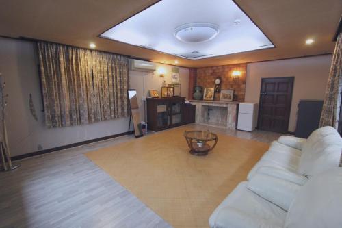 a living room with a white couch and a fireplace at I Osaka Traditional in Osaka