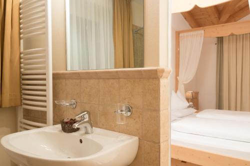 a bathroom with a sink and a bunk bed at Hotel Olympia in San Vigilio Di Marebbe