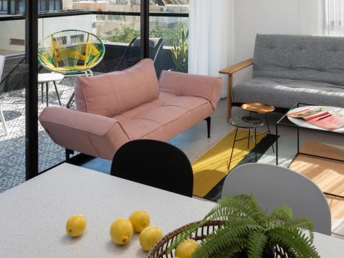 a living room with a pink couch and a table at Mr. Ben Yehuda - By TLV2GO in Tel Aviv