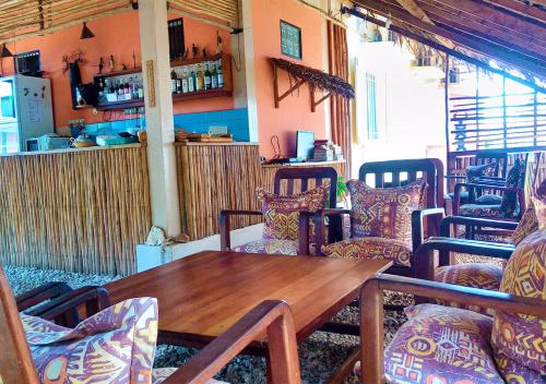 a dining room with a wooden table and chairs at Hotel Le Petit Paradis in Diego Suarez