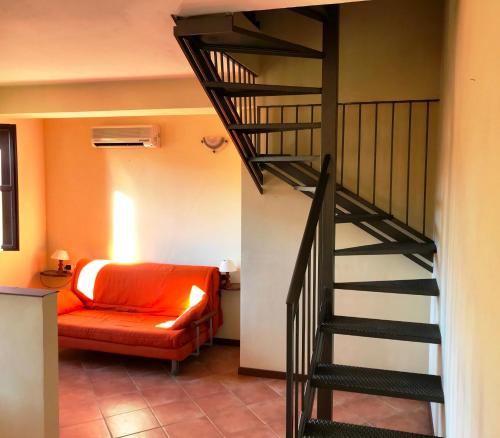 a living room with a staircase and a bed at Borgo Venecca in Fonteblanda